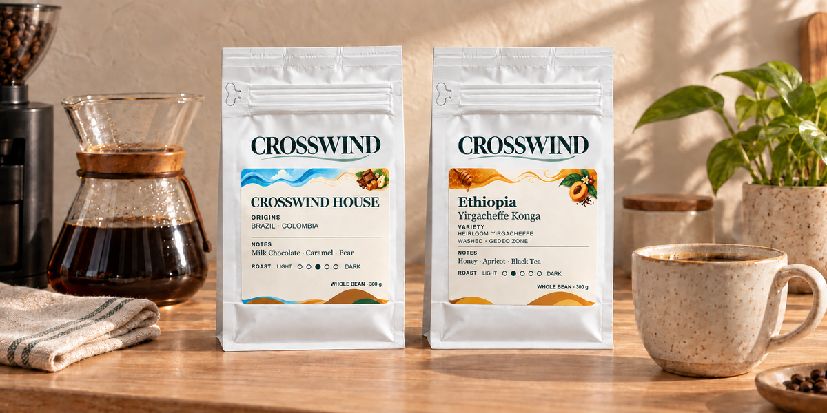 Crosswind House and Ethiopia coffee bags beside a ceramic mug in warm sunlight